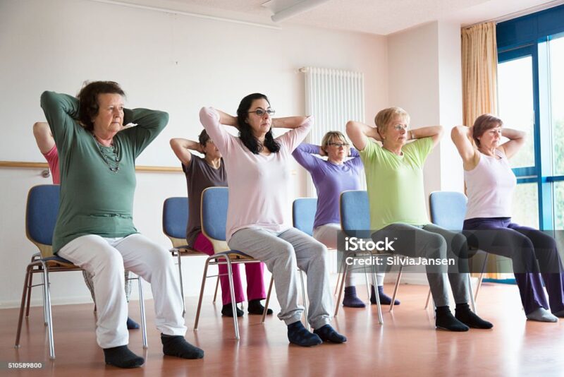 senior women exercising yoga and pilates sitting on chairs
